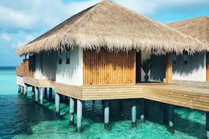 Overwater bungalows with thatched roofs and wooden balconies. - Kudafushi Resort & Spa (Kudafushi)