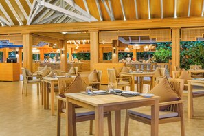 A spacious restaurant with wooden furniture and a high ceiling. - Kudafushi Resort & Spa (Kudafushi)