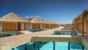 Overwater bungalows with thatched roofs and wooden walkways leading to infinity pools. - Kudafushi Resort & Spa (Kudafushi)