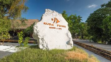A large white rock with the text "Kuda Fushi Resort & Spa" and a logo.