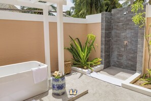 A modern outdoor bathroom with a bathtub, a shower, and a potted plant. - Kudafushi Resort & Spa (Kudafushi)