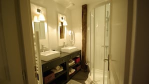 A bathroom with two sinks, a mirror, a shower, and a towel rack. - Logis Relais Du Quercy (Meyssac)