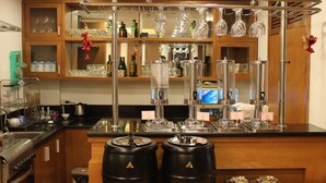 Eine Bar mit einer Theke, Regalen voller Flaschen und Gläsern sowie einer Kaffeemaschine.