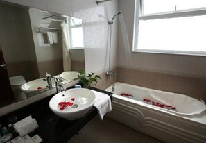 A bathroom with a bathtub, a sink, and a mirror. - Nesta Boutique Hotel Hanoi (Hanoi)