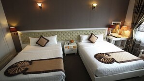 A hotel room with two beds, a tufted headboard, bedside lamps, a nightstand with a phone, and a window with curtains. - Nesta Boutique Hotel Hanoi (Hanoi)