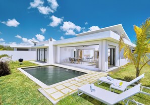 A modern house with a swimming pool, outdoor seating, and a well-maintained lawn. - Corail Bleu Private Pool & Garden Villas By LOV (Cap Malheureux)