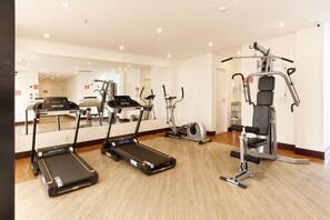 A gym with treadmills, an elliptical, and a weight machine. - Ramada Encore by Wyndham Osasco (Osasco)