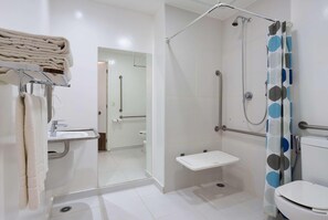 Uma casa de banho moderna com chuveiro, sanita e lavatório.
