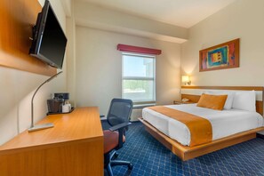A hotel room with a bed, desk, chair, television, window, and artwork on the wall. - Greenwood Hotel Torreon (Torreón)