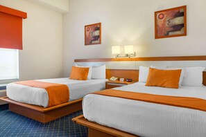 A hotel room with two beds, a nightstand, a phone, and two wall-mounted lamps. - Greenwood Hotel Torreon (Torreón)