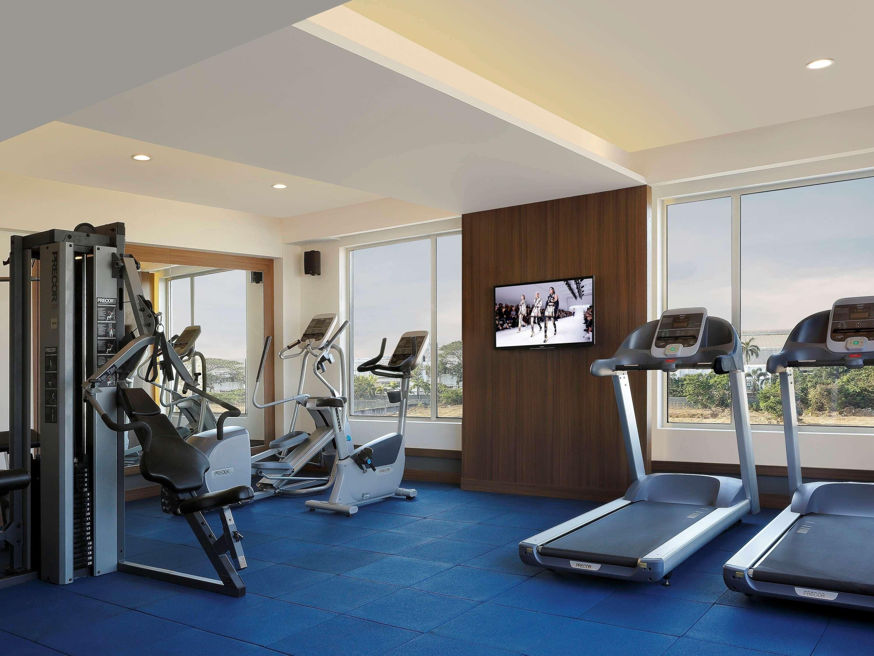 Ein Fitnessstudio mit Laufbändern, Crosstrainern und Gewichtsmaschinen.