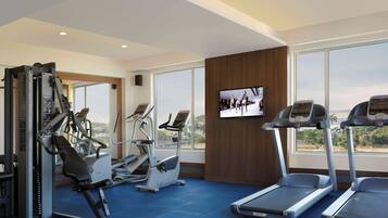 Ein Fitnessstudio mit Laufbändern, Crosstrainern und Gewichtsmaschinen.