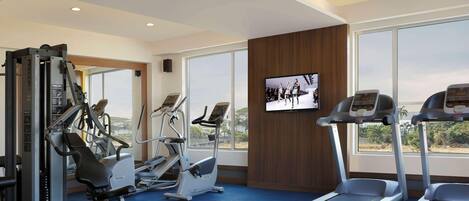 A gym with treadmills, elliptical machines, and weight equipment.