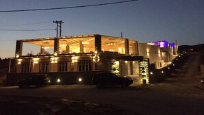 Un edificio de dos pisos con garaje, entrada para vehículos y una escalera que lleva al nivel superior.