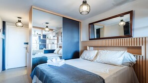 Ein Hotelzimmer mit einem großen Bett, einem Spiegel und einem Kleiderschrank.