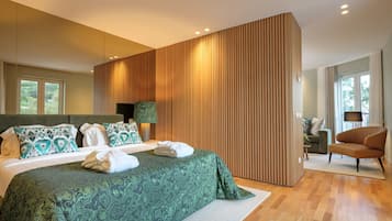 A modern bedroom with a large bed, a wooden accent wall, and a view of the outdoors.