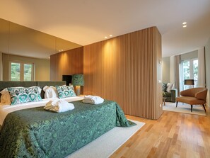 Un dormitorio moderno con una cama grande, un panel de madera decorativo y vistas al exterior.
