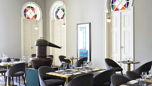 Un restaurante con mesas redondas, sillas y una estufa grande.