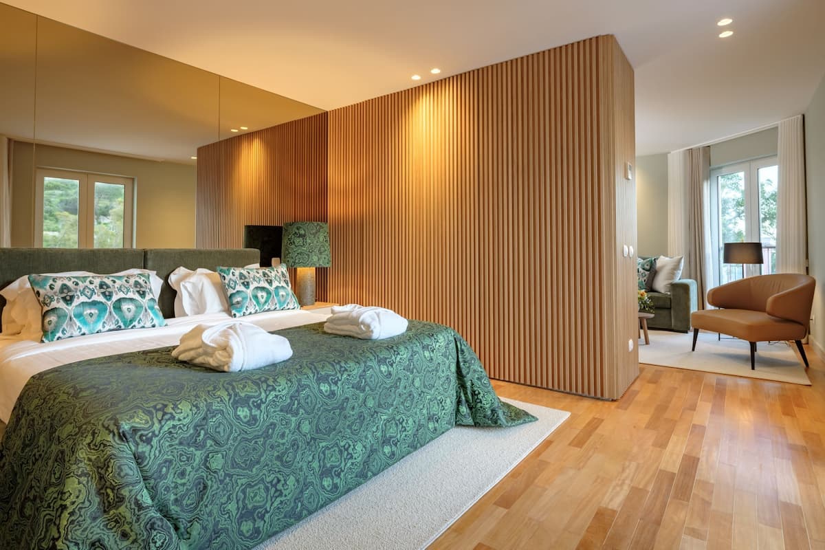 Un dormitorio moderno con una cama grande, un panel de madera decorativo y vistas al exterior.