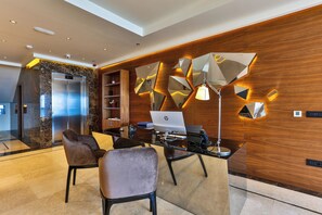 A modern office space with a glass desk, two chairs, an HP laptop, and a wooden wall with geometric light fixtures. - California (Sveti Stefan)