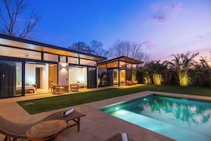 A modern house with a swimming pool, glass doors, and outdoor seating. - Spectacular Villa in Avellanas (Santa Cruz)