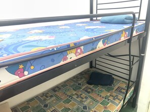 A bunk bed with a blue mattress featuring cartoon characters, a patterned floor, and a metal frame. - Spot ON 89872 Kuantan Backpackers (Kuantan)