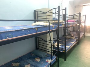 Bunk beds with blue bedding and cartoon prints, a green floor, and a white wall. - Spot ON 89872 Kuantan Backpackers (Kuantan)
