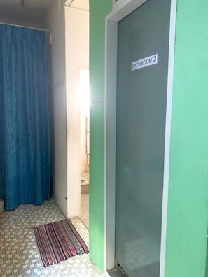 Un baño con un letrero que dice 'Bathroom 2' en una puerta verde.
