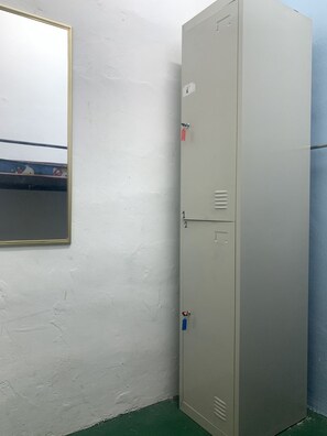 A utility room with a large metal cabinet, a mirror on the wall, and a green floor. - Spot ON 89872 Kuantan Backpackers (Kuantan)