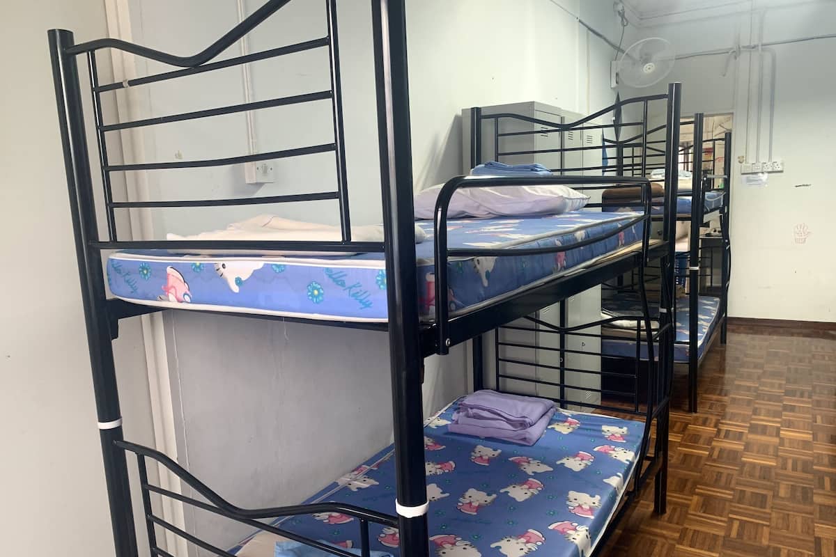 Bunk beds with Hello Kitty bedding, a fan, and a white wall with a window.