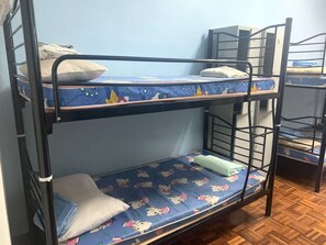 A bunk bed room with a blue patterned mattress, pillows, and a wooden floor. - Spot ON 89872 Kuantan Backpackers (Kuantan)