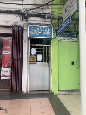 Fachada de una tienda con letreros que indican 'Kuantan Backpackers' y 'Exuviance Beauty Land'.