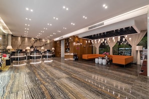 A modern lobby with a reception desk, seating area, and a marble floor. - Paco Hotel Suyuan Metro Guangzhou (Guangzhou)