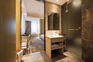A modern bathroom with a sink, mirror, and towel storage. - Paco Hotel Taojin Metro Guangzhou (Guangzhou)