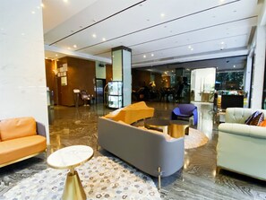 A spacious lobby with seating areas, a reception desk, and a glass partition. - Paco Hotel Taojin Metro Guangzhou (Guangzhou)