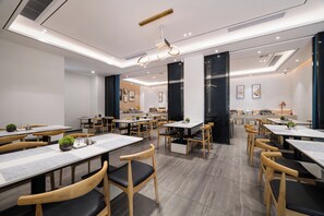 A modern restaurant with wooden tables and chairs, recessed ceiling lighting, and a clean, minimalist design. - Paco Hotel Taojin Metro Guangzhou (Guangzhou)