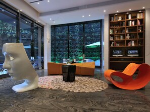 A modern interior with a large window, a bookshelf, and a unique sculpture. - Paco Hotel Taojin Metro Guangzhou (Guangzhou)