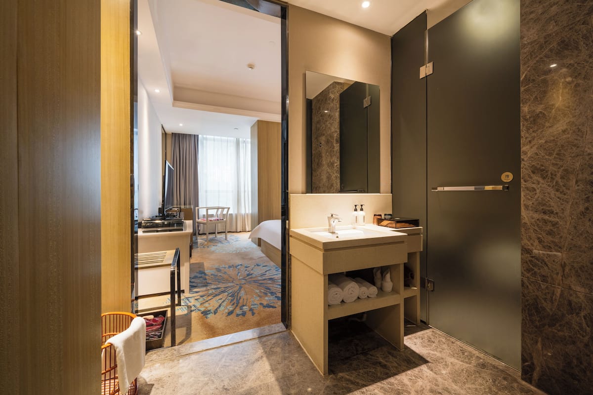 A modern bathroom with a sink, mirror, and towel storage.