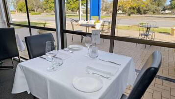 A table set for dining with a view of the outdoors.