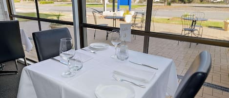 A table set for dining with a view of the outdoors.
