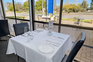 A table set for dining with a view of the outdoors. - Comfort Inn Flinders On Main (Beetaloo Valley)