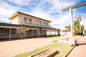 A motel with a flat roof, large windows, and a sign indicating 'Flinders Motel on Main.' - Comfort Inn Flinders On Main (Beetaloo Valley)
