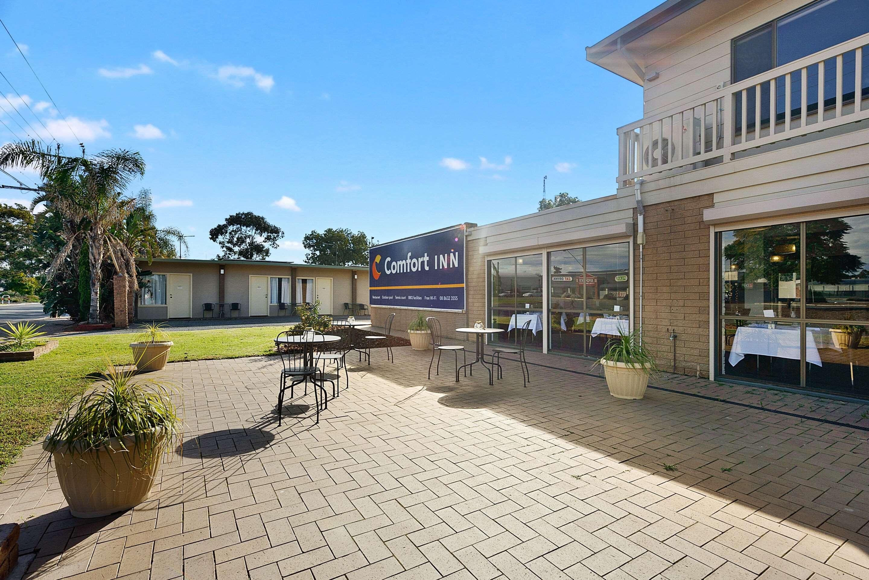A Comfort INN with a patio area featuring outdoor seating and potted plants.