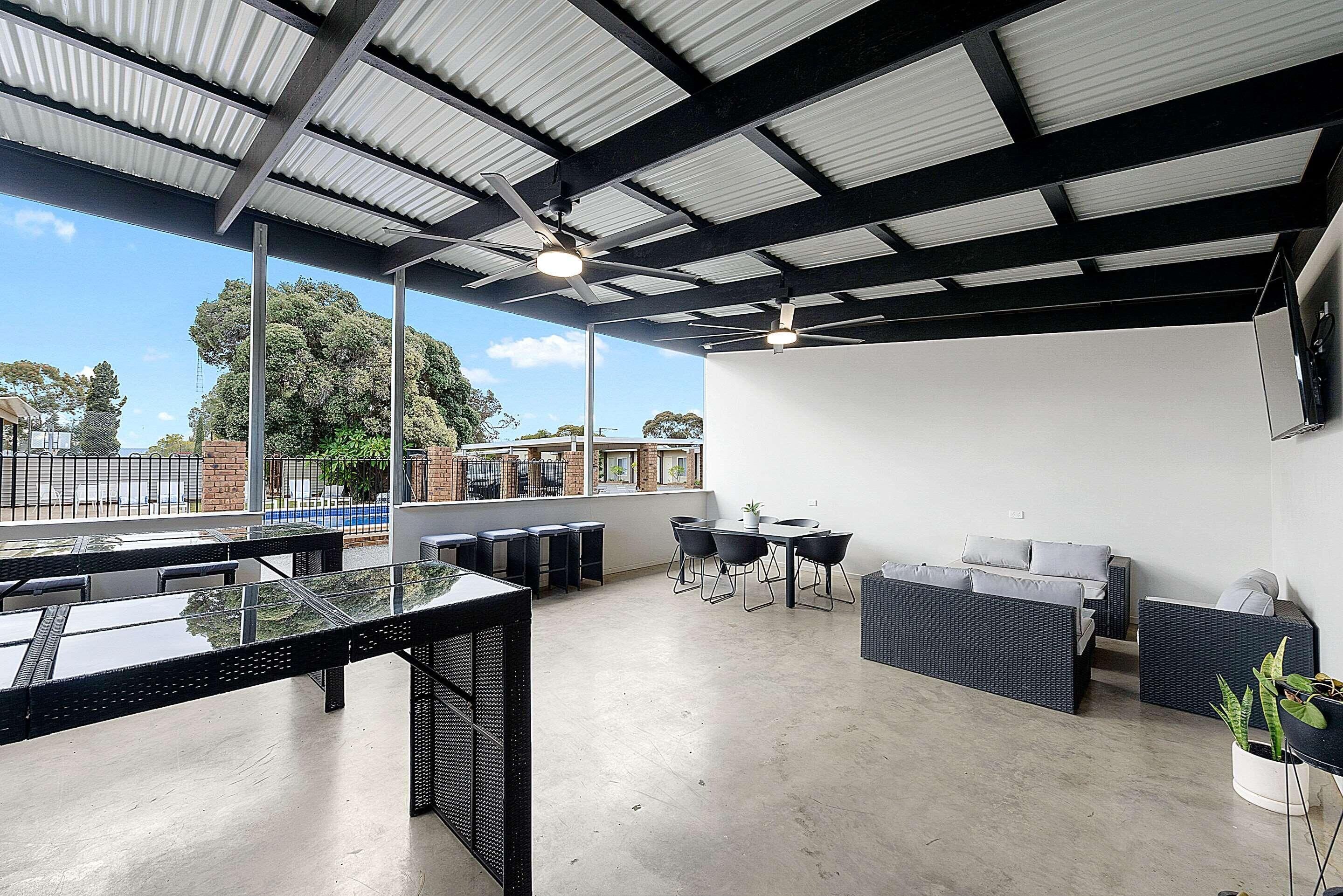 Un espacio interior amplio con techo alto, ventanas grandes y una disposición de asientos.