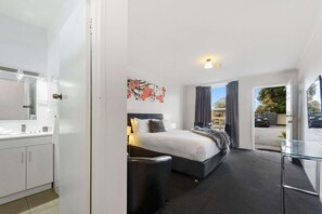 A modern hotel room with a bed, bedside table, and a view of the outside. - Comfort Inn Flinders On Main (Beetaloo Valley)