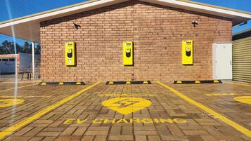 An EV charging station with three yellow charging points on a brick building.