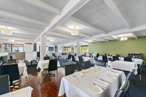 A spacious dining area with multiple tables, white tablecloths, and modern chandeliers. - Comfort Inn Flinders On Main (Beetaloo Valley)