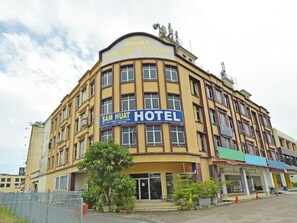 Um hotel com uma placa grande exibindo "SAM HUAT HOTEL".