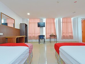 A hotel room with two beds, a desk, a chair, a television, and a wardrobe.
