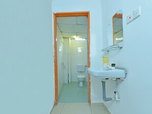 A bathroom with a white sink, a mirror, and a toilet.